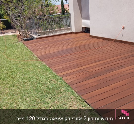 דק עץ חום ליד דשא ירוק בגינה